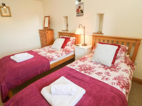 two beds sitting next to each other in a room at Old Hall Byre in Leyburn