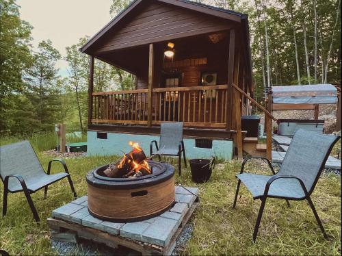 una hoguera en un patio con sillas y una cabaña en Dreamy Couples Cabin in the Shenandoah Forrest, en Luray
