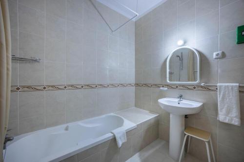 een badkamer met een wastafel en een bad en een wastafel bij Villas Brites nº3 in Burgau