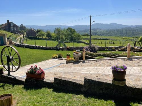 O Balcon Do Oitaven, vuestra finca privada en Galicia في بونتيفيدرا: حديقة مع فناء حجري مع ورود في الأواني