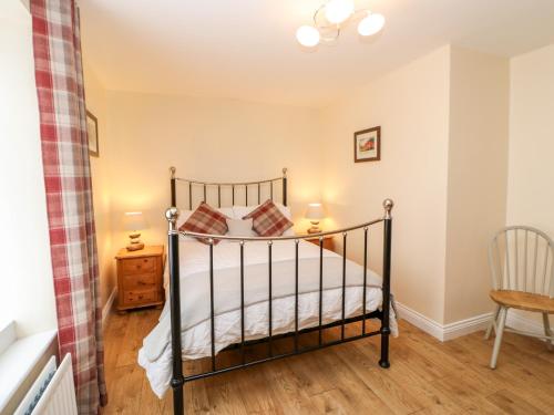 um quarto com uma cama e uma cadeira em Bracken Cottage em Bishop Auckland