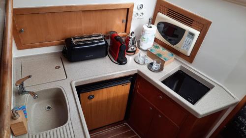 una pequeña cocina con fregadero y microondas en Yaku Wayra Charter en Playa Blanca
