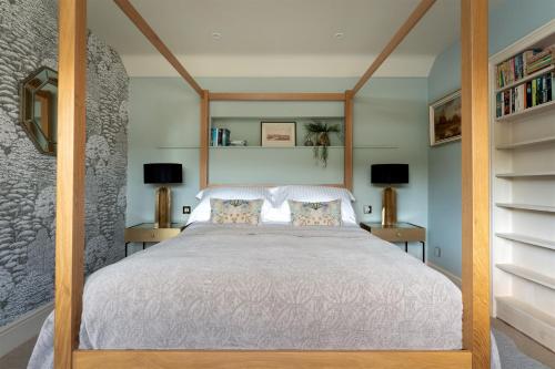 a bedroom with a white bed with two lamps at Higher Mapstone - A true retreat nestled in a private sanctuary on Dartmoor in Newton Abbot