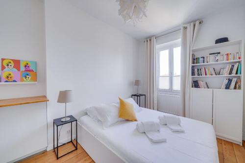 - un lit blanc dans une chambre blanche avec une étagère dans l'établissement LE HUGUE UP - Bel appartement en plein coeur de Bordeaux, à Bordeaux