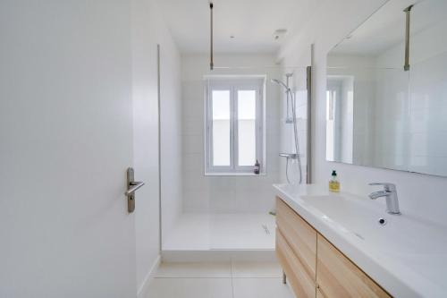 une salle de bain blanche avec un lavabo et une douche dans l'établissement LE HUGUE UP - Bel appartement en plein coeur de Bordeaux, à Bordeaux