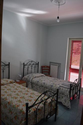 a bedroom with two beds and a window at Guardia Piemontese: Ideale per Mare e Terme in Guardia Piemontese Terme