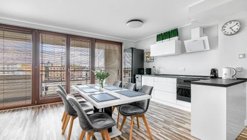 - une cuisine et une salle à manger avec une table et des chaises dans l'établissement Comfy Apartments - Transatlantyk Lux, à Gdynia