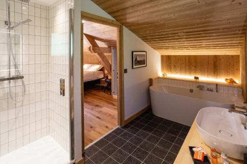 y baño con bañera, lavamanos y ducha. en Chalet du Gouter - Chamonix All Year en Chamonix-Mont-Blanc