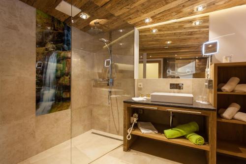 a bathroom with a shower and a sink at Hotel Neuhaus in Saalbach Hinterglemm