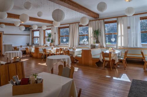 a restaurant with tables and chairs and windows at Hotel Restaurant Alatsee in Füssen
