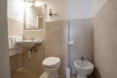 a small bathroom with a toilet and a sink at Amadei Hotel Blumen in Pesaro