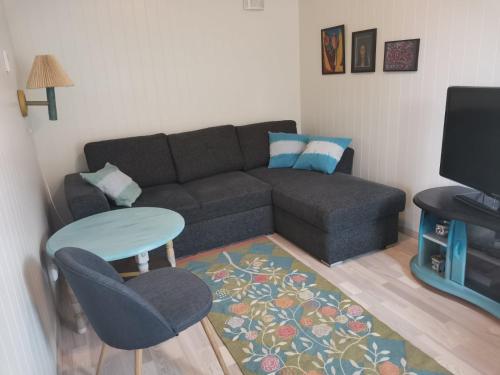 a living room with a couch and a table at Karlotte's apartment in Ballstad