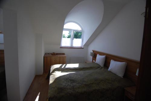 a bedroom with a bed and a window at Ivanek guest house in Zvíkovské Podhradí