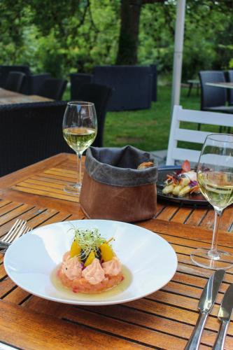 a table with a plate of food and two glasses of wine at Moulin de Fourges in Fourges