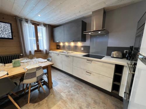 une cuisine avec une table en bois et une salle à manger dans l'établissement Gentianes 2 - Appartement centre village et proche pistes de ski, à La Clusaz