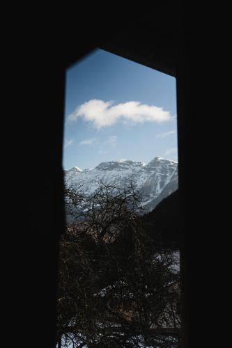a view of a snow covered mountain from a window at Roja House in Soča