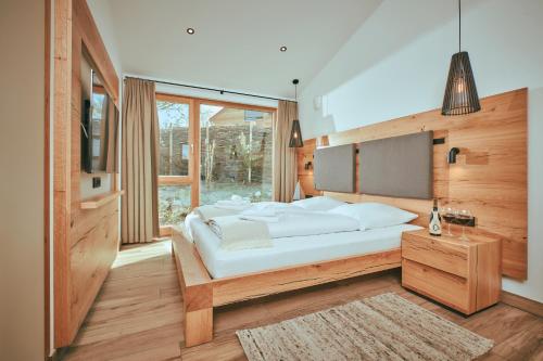 a bedroom with a large white bed and a window at Chalet Resort Seenland in Steinberg