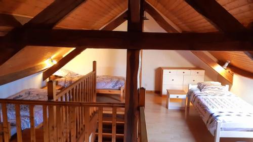 a attic room with two beds and a staircase at Gites Le Clos de Lamie avec 2 piscines privées in Fossemagne