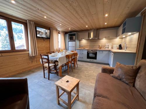 un salon avec une table et une cuisine dans l'établissement Gentianes 4 - Appartement centre village, à La Clusaz