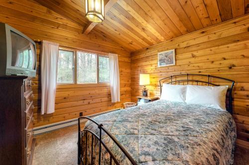 ein Schlafzimmer mit einem Bett in einem Blockhaus in der Unterkunft Franconia Cabin Retreat in Franconia