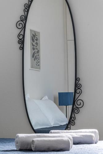 a mirror on a table with a bed in a room at Sea view Pine house in Makry Gialos