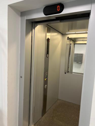 an elevator door in a train with a clock on it at Apartment Comfort in Bartoszyce