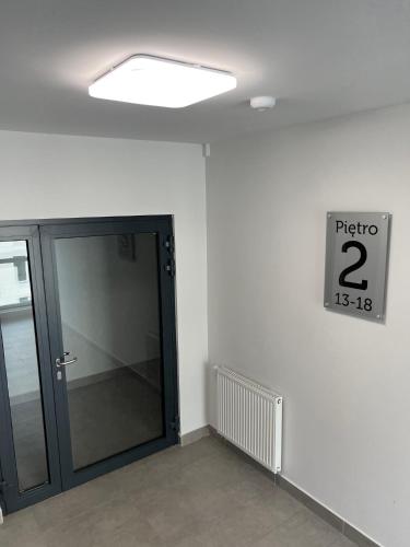 an empty room with a door and a sign on the wall at Apartment Comfort in Bartoszyce
