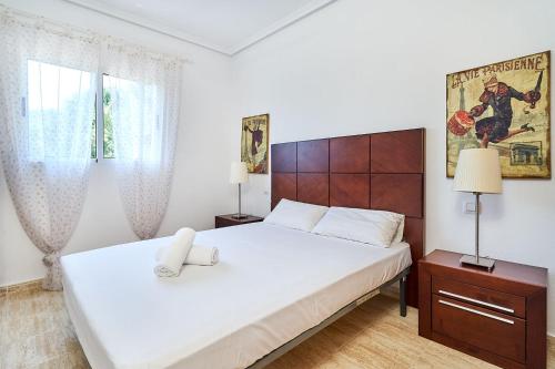 a bedroom with a large white bed and a window at Espanhouse Rio Mar in Pilar de la Horadada