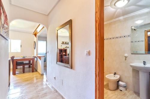 a bathroom with a sink and a toilet and a mirror at Espanhouse Rio Mar in Pilar de la Horadada