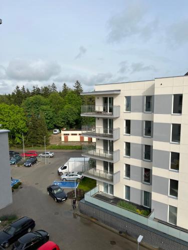 an apartment building with cars parked in a parking lot at Apartment Comfort in Bartoszyce