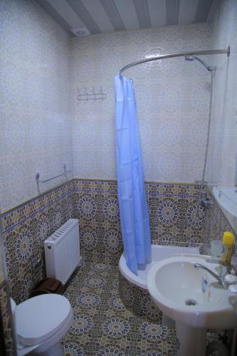 a bathroom with a toilet and a sink and a shower at Hotel Mironshox in Bukhara