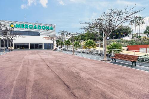 a empty parking lot with a bench in front of a building at Refugio Vacacional in Granadilla de Abona