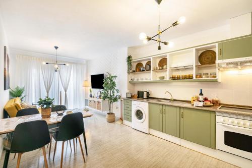 a kitchen and dining room with green cabinets and a table at Refugio Vacacional in Granadilla de Abona