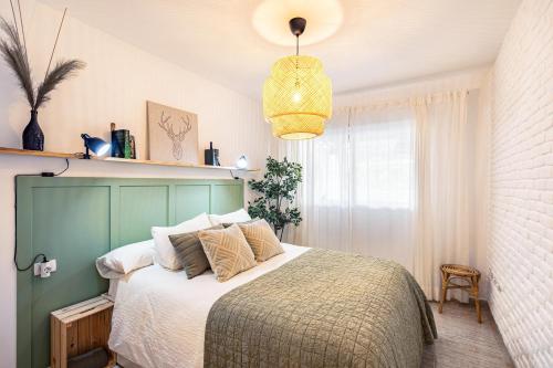 a bedroom with a large bed with a green headboard at Refugio Vacacional in Granadilla de Abona