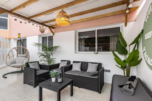 a patio with chairs and a couch and a table at Refugio Vacacional in Granadilla de Abona