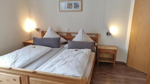 - une chambre avec 2 lits et des draps blancs dans l'établissement Haus Borkumitte Appartement Poseidon, à Borkum