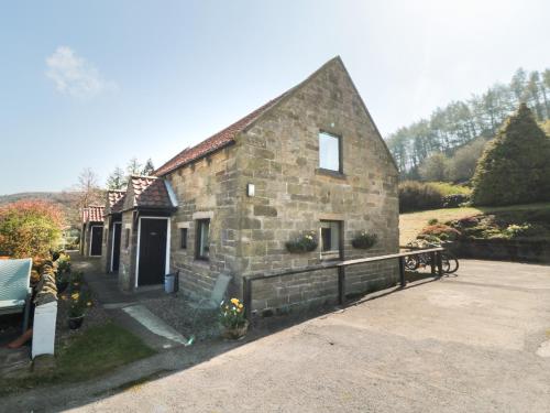 an old stone house with a bench in front of it at Farndale in Whitby