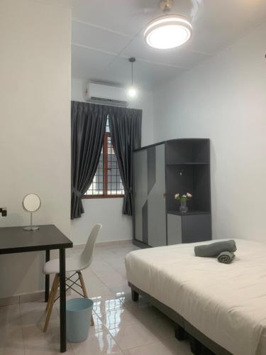 a bedroom with a bed and a desk and a table at Queen Room Semi Attached Bathroom Bukit Mertajam Alma Impian in Bukit Mertajam