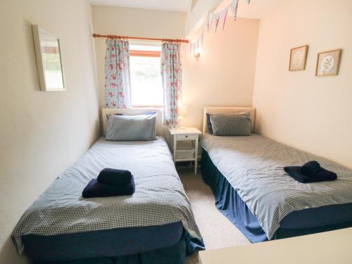 two beds in a small room with hats on them at Glaisdale in Whitby