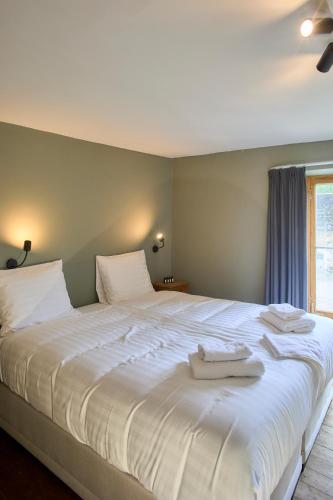 a large white bed with two white towels on it at Château de la Chapelle in Anthisnes