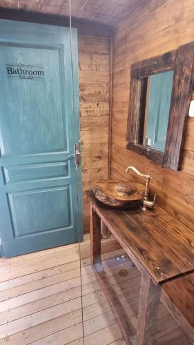 a bathroom with a sink and a mirror and a door at Domaine Authentique de Rose in Porto-Vecchio