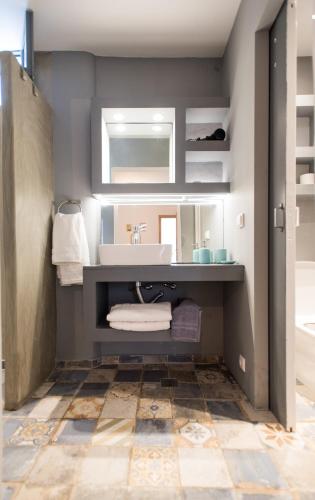 a bathroom with a sink and a mirror at mykonos 1001 in Agios Stefanos