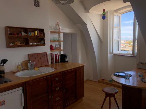 La salle de bains est pourvue d'un lavabo et d'un comptoir avec une fenêtre. dans l'établissement La Hune Vauban - Appartement avec vue mer & port, à Saint-Malo