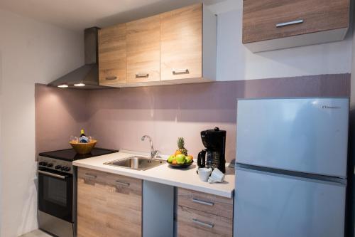 a kitchen with a white refrigerator and a sink at mykonos 1001 in Agios Stefanos