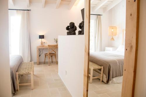 Un dormitorio blanco con una cama y una mesa. en 120 Hotel Boutique - Adults Only, en Ciutadella