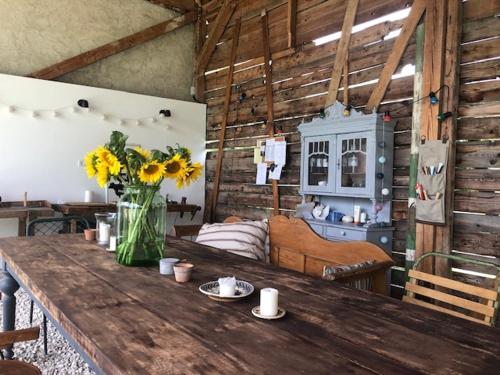 a room with a wooden table with a vase of flowers at Nemespécsely Udvarház in Pécsely