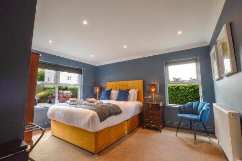 a bedroom with a large bed and two windows at Raniven in Oban