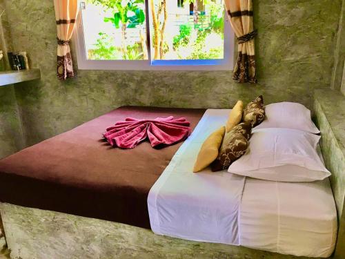 a bedroom with a bed with pillows and avertisement at New Moon in Thongsala