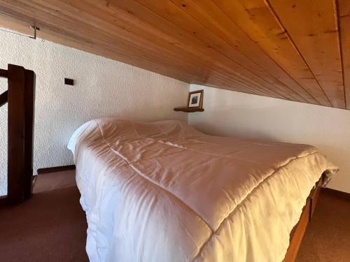 un lit dans une chambre avec un plafond en bois dans l'établissement Richemont 12 - Duplex proche pistes vue, à La Clusaz