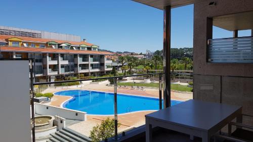 una vista sulla piscina dal balcone di un edificio di URBANIZACIÓN ILLAS ATLANTICAS-PORTONOVO a Sanxenxo